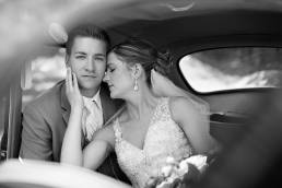 wedding couple sitting inside a car